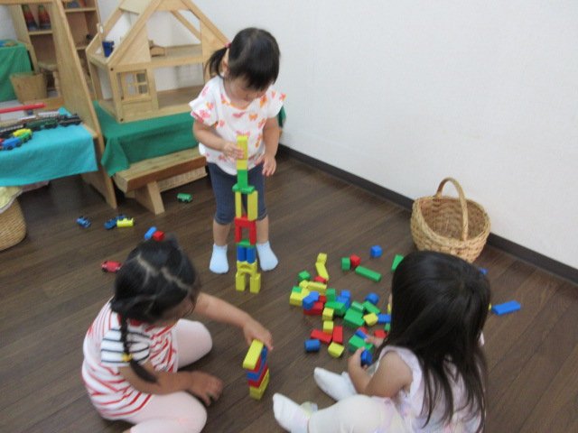 積み木を高く積み上げたり、組み立てたりして集中して遊ぶ幼児クラスの様子"