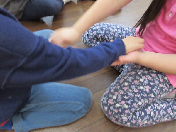 創造教室こびとのおうち 幼児クラスで手と手を合わせ、わらべ歌遊びをする子どもたちの様子