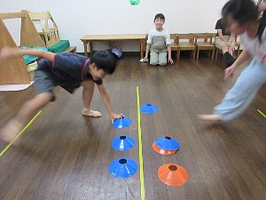 小学生クラスの、コーンを使った俊敏性や動きを競うゲーム活動